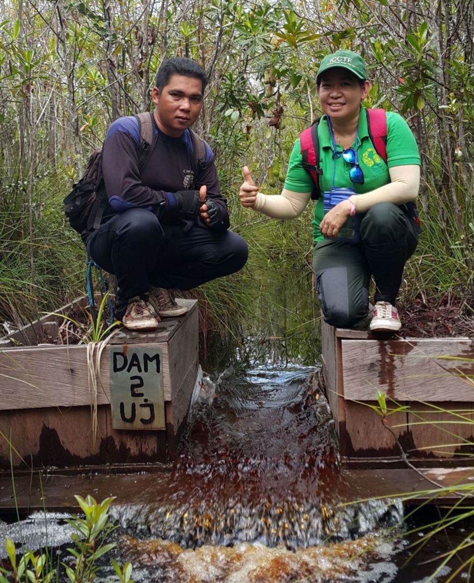Zwei Mitarbeiter der Borneo Nature Foundation auf einem Damm.