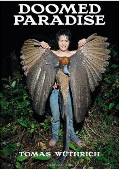 Buchcover von "Doomed Paradise" mit einem Penan, der einen grossen toten Vogel in die Höhe hält.